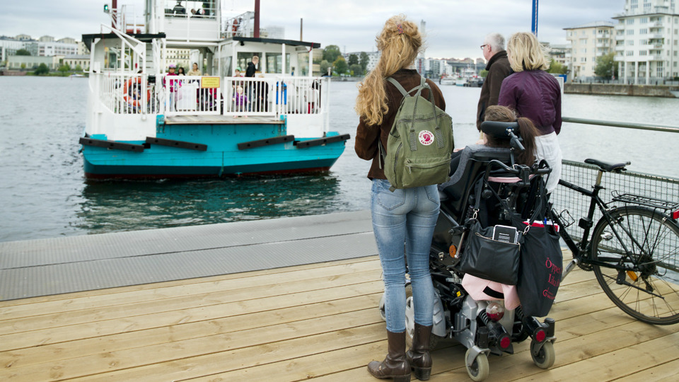 Personer - en av dem en rullstolsanvändare - som väntar på en stadsfärja.